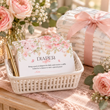 Baby in bloom diaper raffle cards in a white basket next to diapers tied with blush ribbon