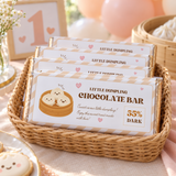 Basket of chocolate bars in little dumpling 1st birthday wrappers on a party favor table