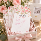 Baby shower advice cards collected in a keepsake box next to a baby photo album