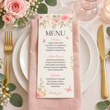 Baby in bloom baby shower menu card on a plate with a blush napkin and gold cutlery