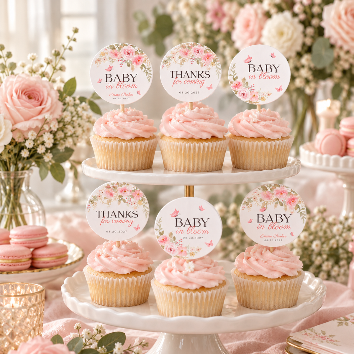 Baby shower dessert table with a tiered cupcake stand and pink floral toppers