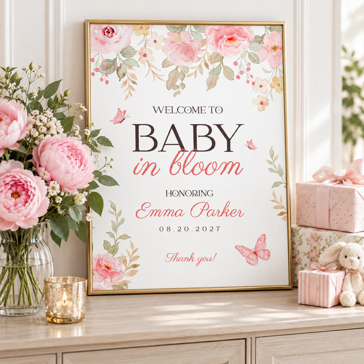 Pink floral baby shower welcome sign in a gold frame with peonies and gifts