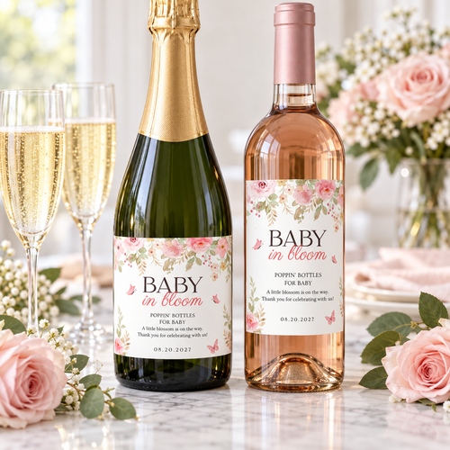 Champagne and wine bottles with baby in bloom labels next to flutes and pink roses