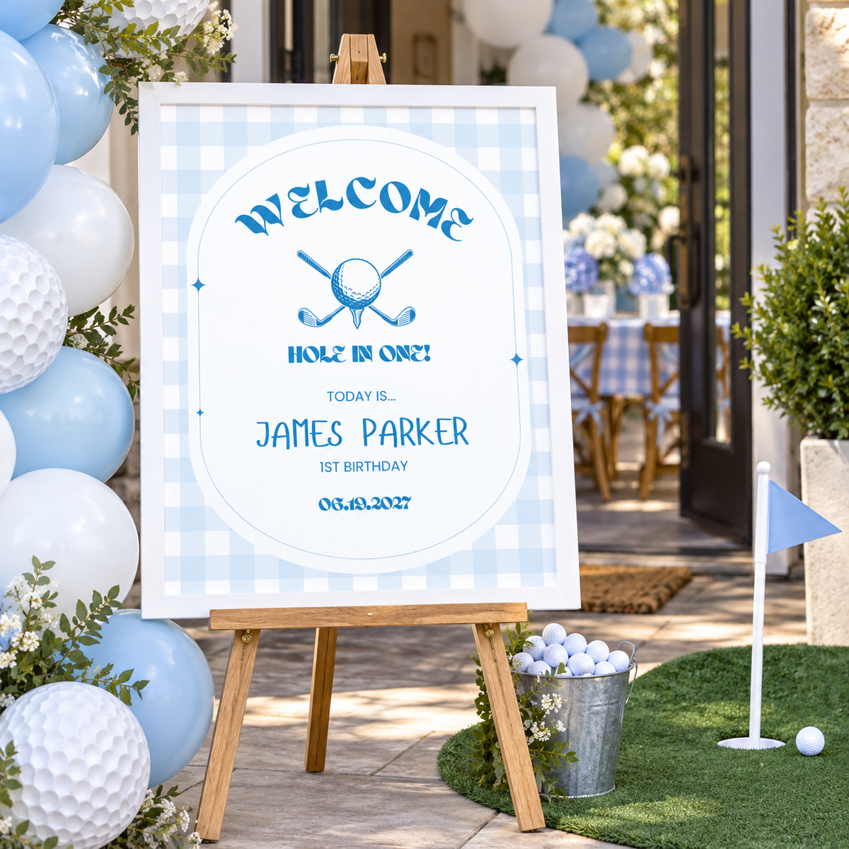 Golf hole in one 1st birthday welcome sign in a white frame on an easel at a party entrance