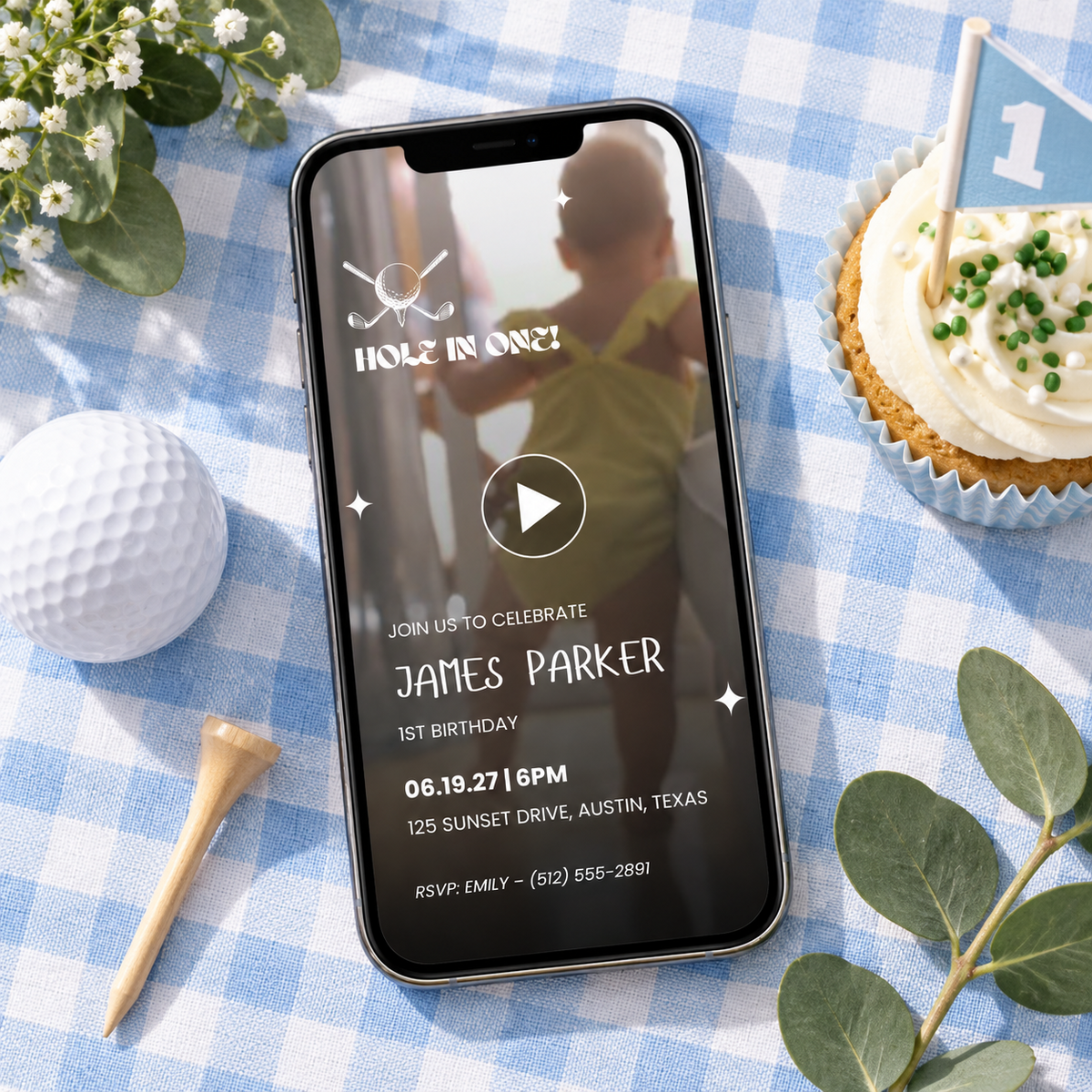 Smartphone with the golf 1st birthday video invitation on a blue gingham tablecloth