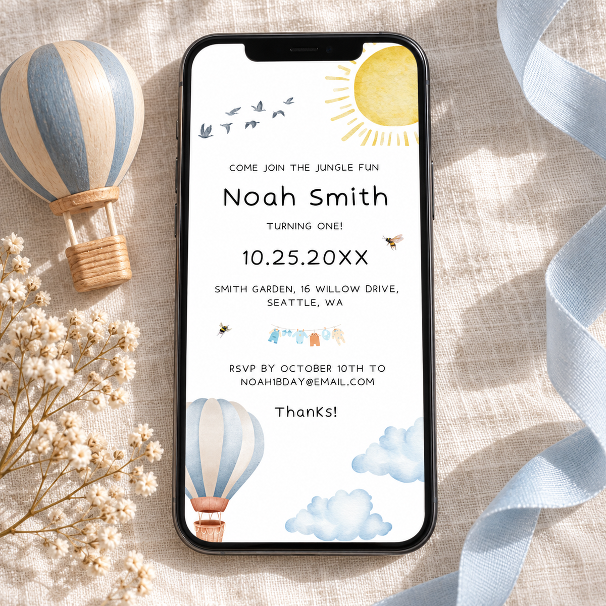 Matching hot air balloon 1st birthday e-vite on a phone screen, editable in Canva