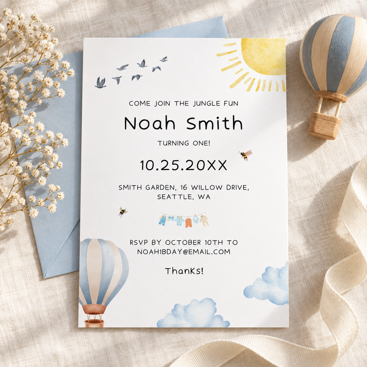 Hot air balloon 1st birthday invitation printable template in watercolor, flat lay with a wooden toy balloon