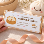 Close-up of a chocolate bar in the dumpling birthday wrapper next to a dumpling plush