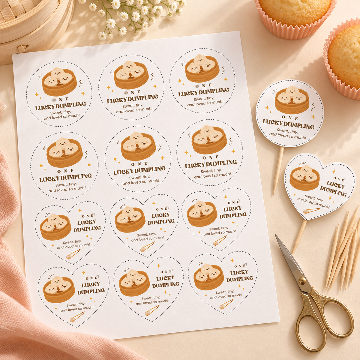 Flat lay of a printed sheet of little dumpling cupcake toppers with scissors and cupcake picks