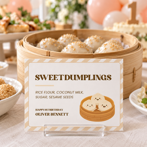 Little dumpling food label in an acrylic stand in front of a steamer of sesame dumplings