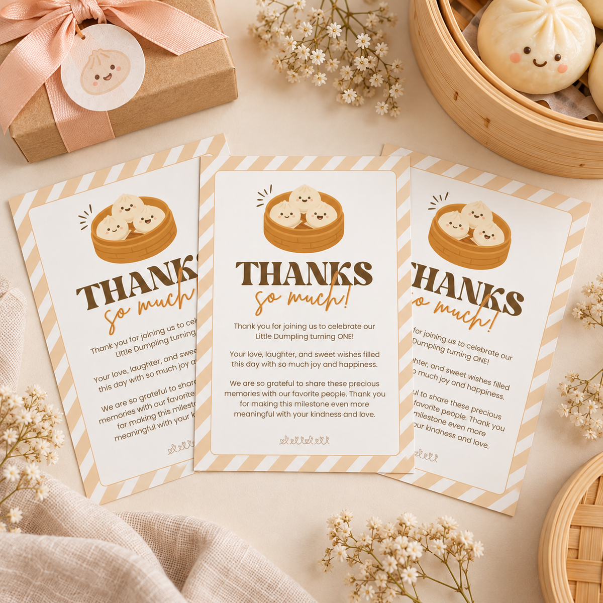 Flat lay of three little dumpling thank you cards with a favor box and bamboo steamer