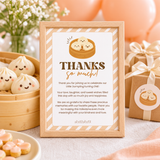 Little dumpling 1st birthday thank you card in a wooden frame on the gift table
