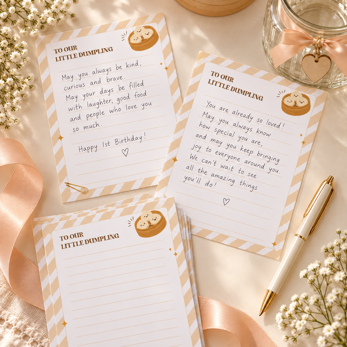 Flat lay of handwritten little dumpling time capsule cards with a pen, ribbon and baby's breath