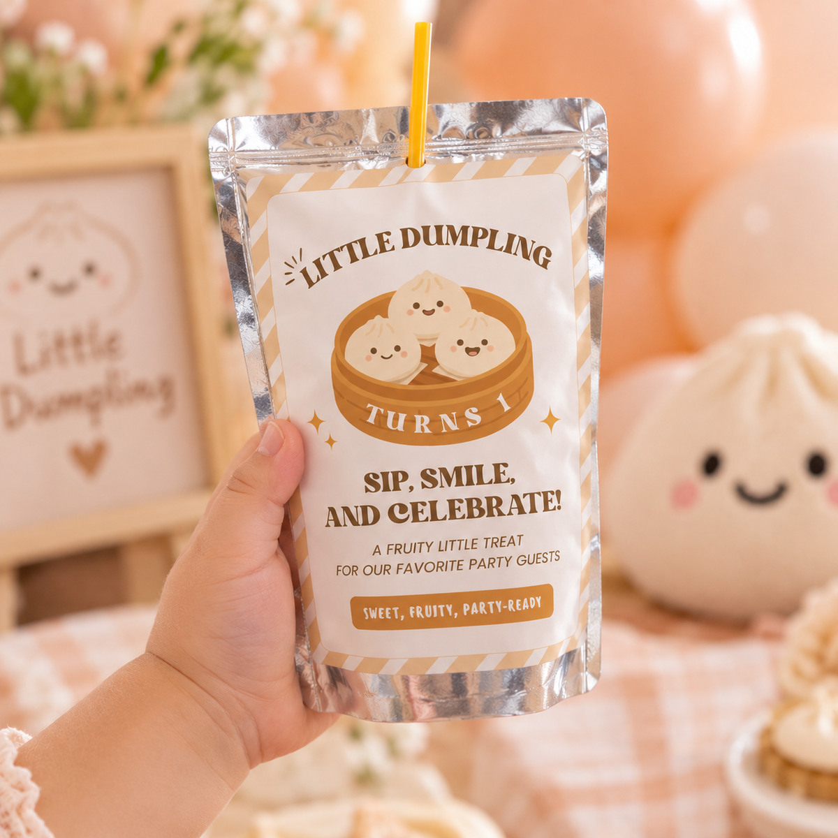Close-up of a little dumpling 1st birthday juice pouch label held by a toddler