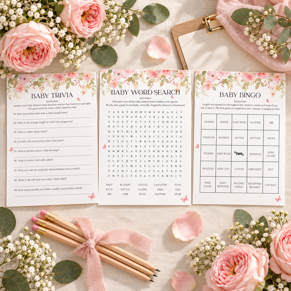 Flat lay of printable pink floral baby shower game cards with pencils and roses