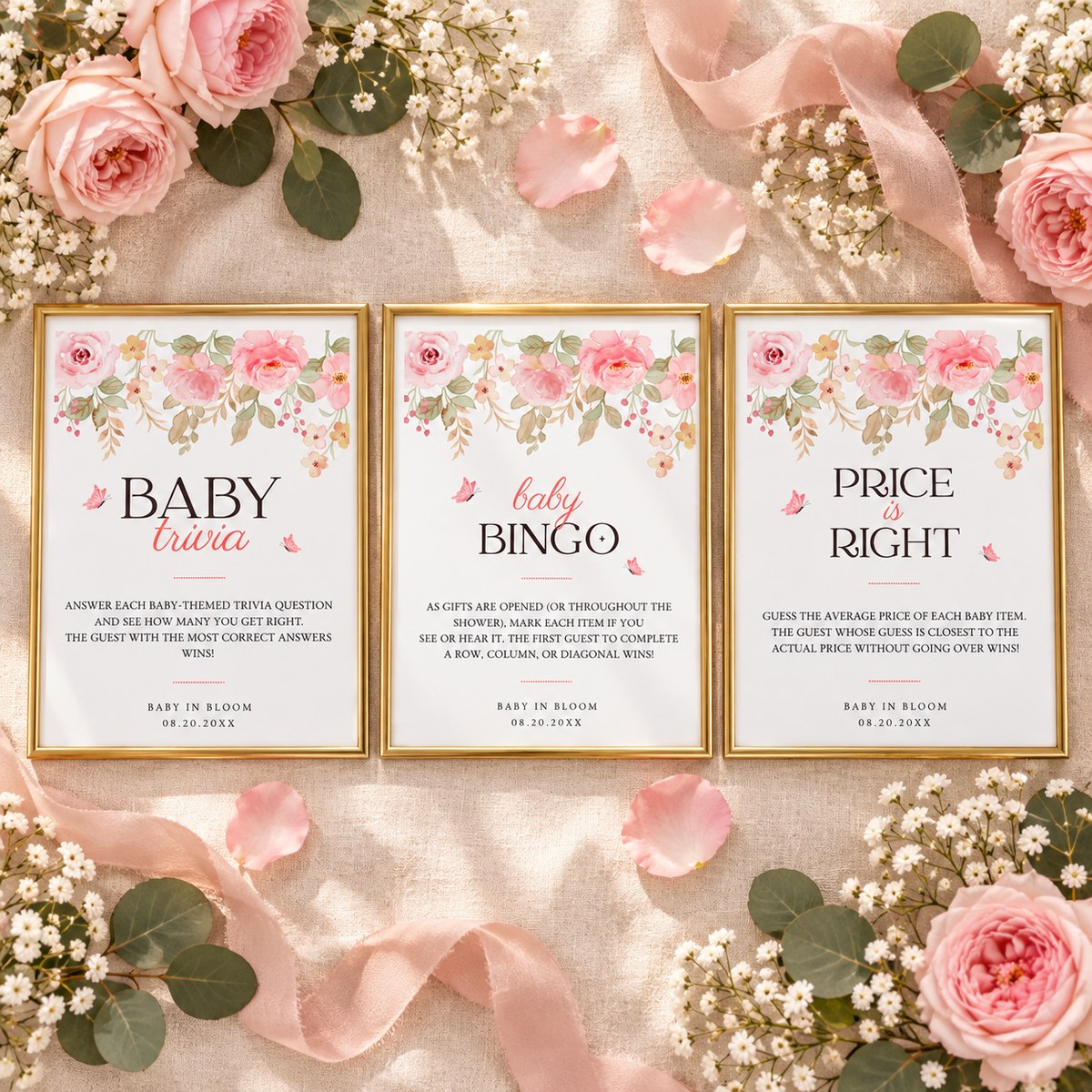 Flat lay of three framed pink floral baby shower game signs with rose petals