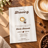 Baby Is Brewing baby shower invitation printed 5x7 on a cafe table with a latte and coffee beans