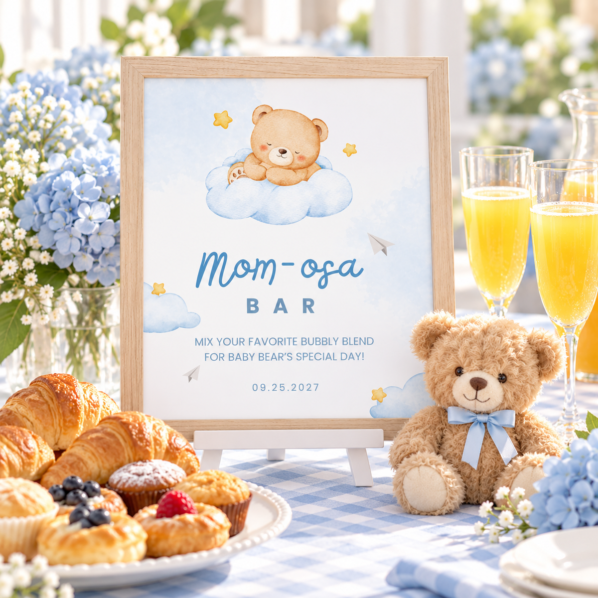 Little Bear Mom-osa bar sign with teddy bear, croissants and mimosas on a blue baby shower table