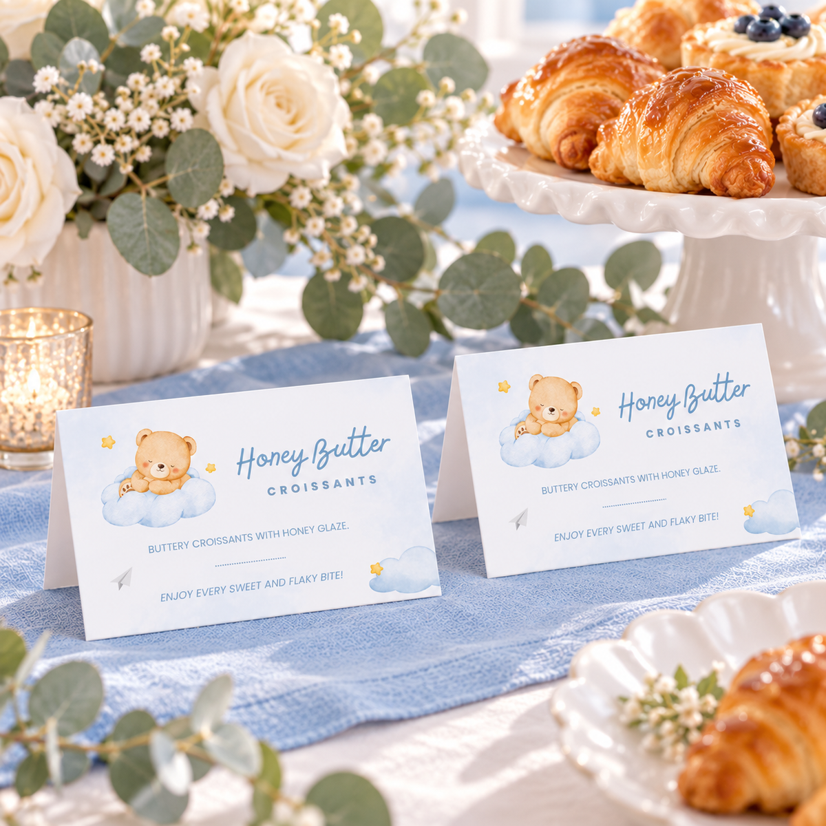 Little Bear food tent cards on a dessert table with eucalyptus and white roses