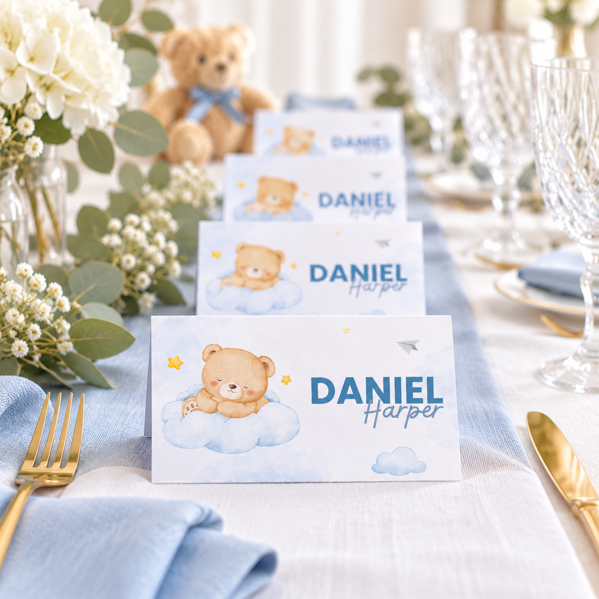Row of Little Bear place cards along a long baby shower table with greenery