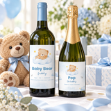 Little Bear baby shower wine and champagne bottle labels on a gift table with a teddy bear and blue ribbon