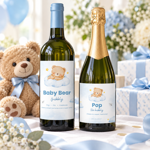 Little Bear baby shower wine and champagne bottle labels on a gift table with a teddy bear and blue ribbon