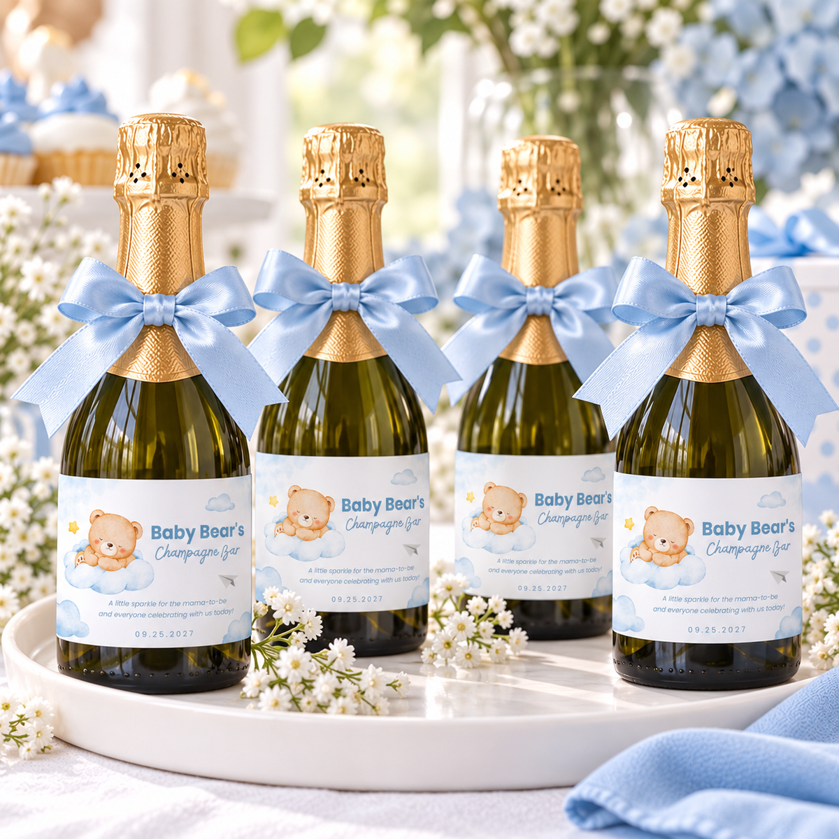 Little Bear mini champagne bottle labels on favor bottles with blue bows on a tray