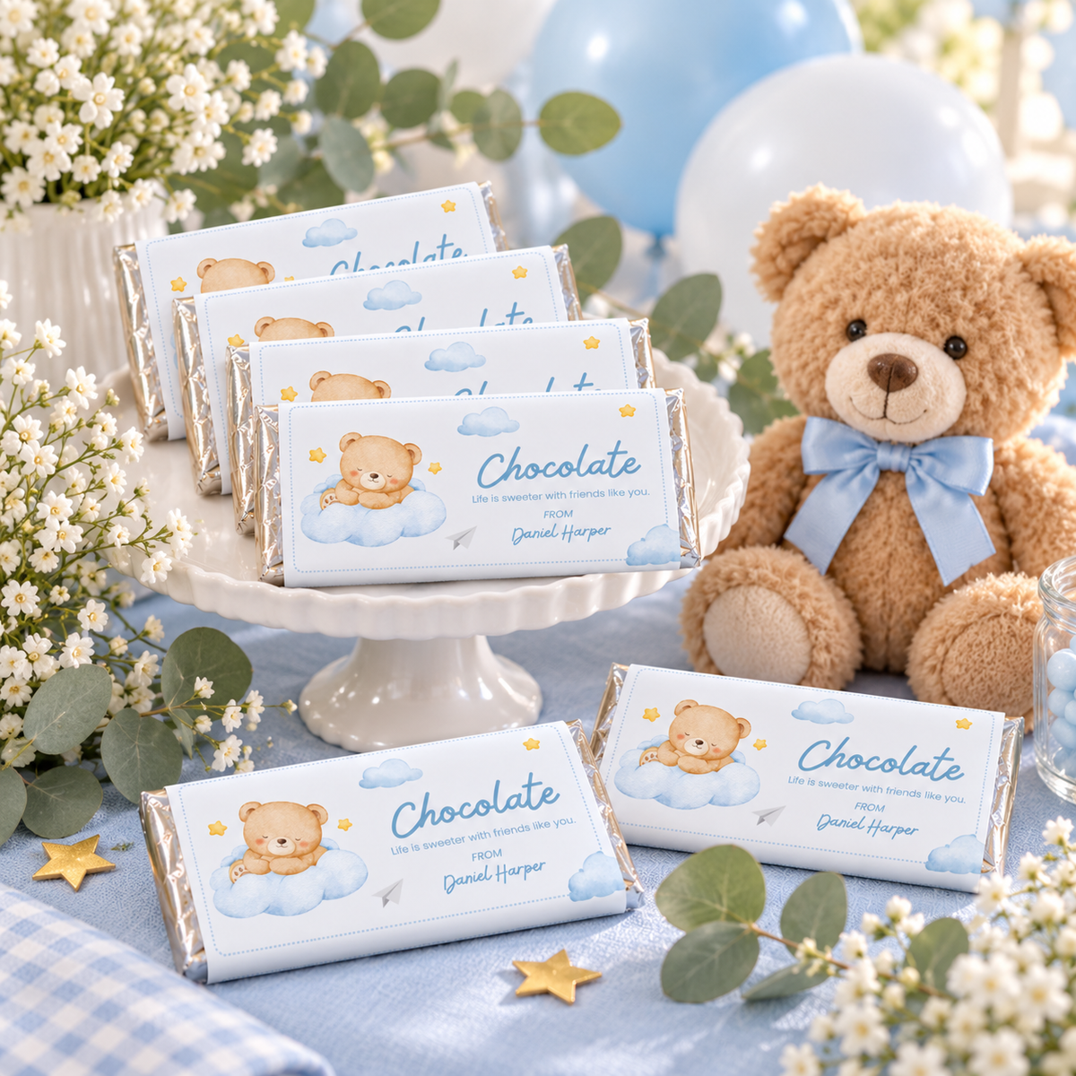 Little Bear chocolate bars on a baby shower favor table with a teddy bear and greenery