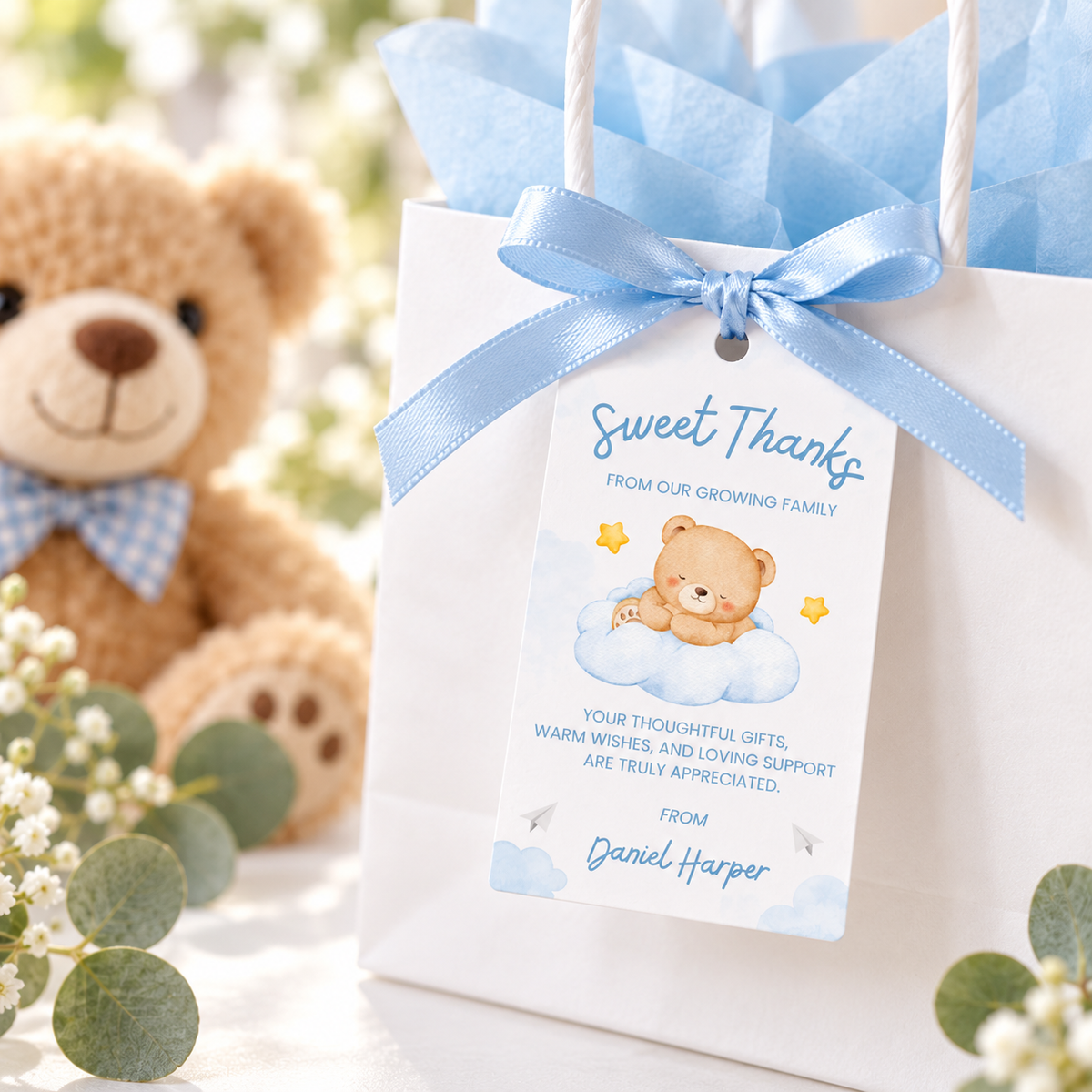 Close-up of a Little Bear Sweet Thanks favor tag on a white gift bag with blue ribbon