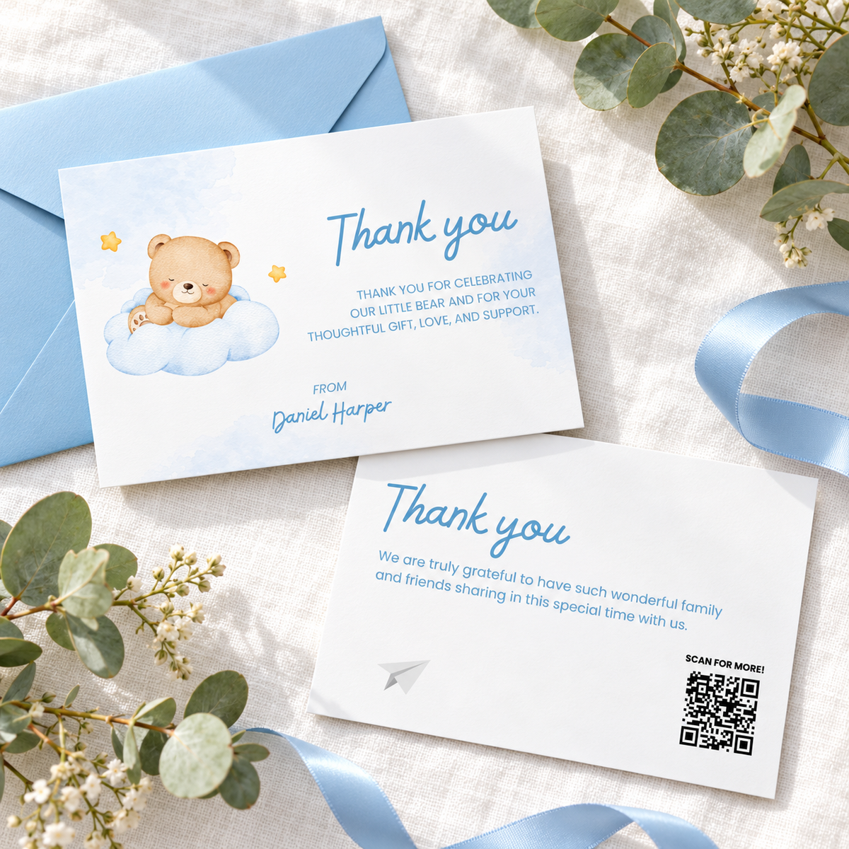 Flat lay of the Little Bear thank you card front and back with eucalyptus and blue ribbon
