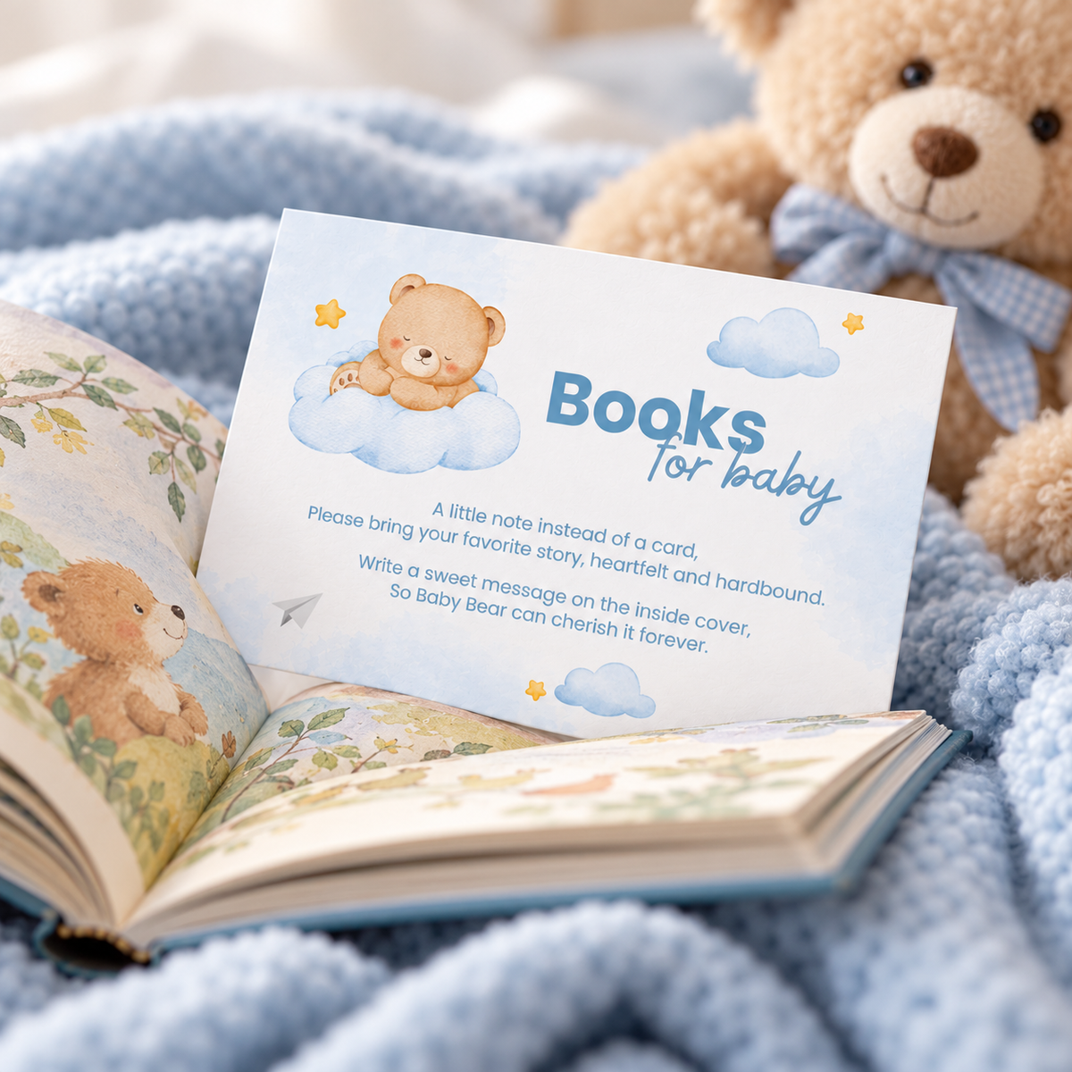 Close-up of the Little Bear books for baby card tucked into an open picture book on a blue blanket