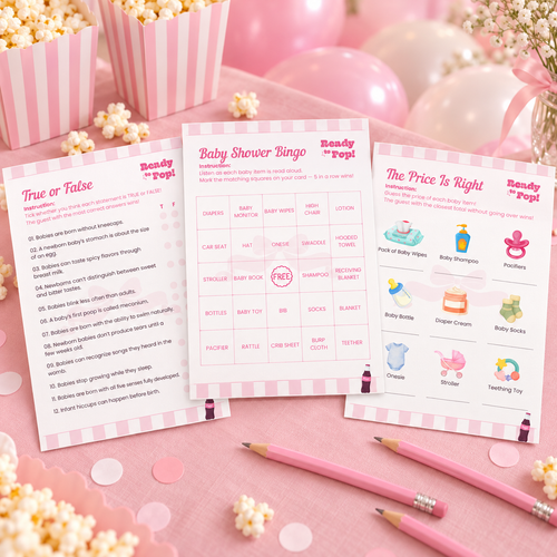 Ready To Pop baby shower game cards fanned out on a pink party table with pencils, striped popcorn boxes and balloons