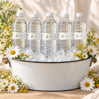 Classic Honey Bear baby shower water bottle labels on bottles in a white enamel ice bucket with daisies and yellow wildflowers