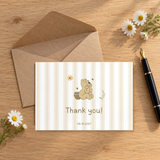 Classic Honey Bear baby shower thank you card on a wooden desk with a kraft envelope, fountain pen and daisies