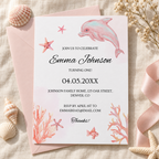 Under the sea 1st birthday invitation printable template with a watercolor pink dolphin and coral, flat lay with seashells